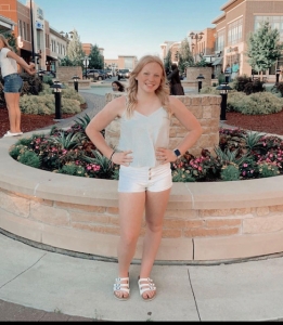 Savannah Gunn posing outside near flowerbed